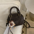 Detail of vintage brown suede bowling bag with embossed logo and fuzzy charm - Coffee with Pendant