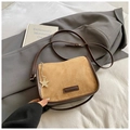 Close-up of suede crossbody bag with star metal pendant on a blazer background - Khaki With Pendant
