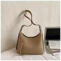 Detalle de bolso hobo de cuero marrón claro con textura litchi en escritorio minimalista - Caqui