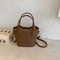 Detailansicht der braunen Bucket-Bag aus Leder mit Narbenstruktur und Goldbeschlägen - Braun (Ohne Anhänger)