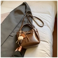 Minimalistische dunkelbraune Leder-Eimertasche mit Metalldrehverschluss und Anhänger - Braun mit Anhänger