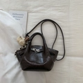 Détail de la texture cuir marron foncé et boucle argentée sur le sac seau chic - Café avec Pendentif