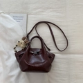 Détail du sac seau bordeaux en cuir verni plissé avec fermoir argenté et breloque ours en peluche - Rouge avec Pendentif