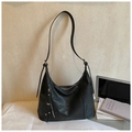 Schwarze Hobo-Tasche mit Nieten und Fransen-Details in gemütlicher Wohnzimmer-Atmosphäre - Schwarz