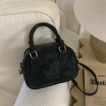 Retro black bowling bag in matte leather finish with gold hardware on a sofa - Black without Pendant