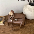 Detail der braunen Vintage-Ledertasche mit silbernem Drehverschluss und Bärenanhänger - Mit Anhänger / Braun