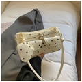 Détail d'un mini sac à main crème à pois avec pendentif cœur et finitions dorées - Blanc