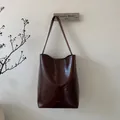 Nahaufnahme der Vintage dunkelbraunen Wachsleder-Eimertasche mit Textur und Logo - Braun
