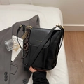 Minimalistische schwarze Eimer-Umhängetasche aus Leder mit goldenem YNGE & VIER Logo - Schwarz mit Anhänger