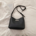 Detailed macro view of black lychee grain leather bag with a silver metallic turn-lock - Black