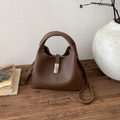 Detail of dark brown lychee grain leather bucket bag with silver metal twist lock buckle - Brown