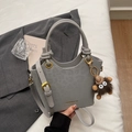 Minimalistische graue Handtasche aus Kunstleder mit Goldbeschlägen und Plüsch-Anhänger - Silber