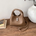 Detail der dunkelbraunen Eimertasche aus genarbtem Leder mit silbernem Metalldrehverschluss - Braun