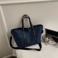 Dettaglio della borsa tote in nylon blu con rivetti argentati e cinturini neri - Blu