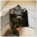 Bolso tote negro minimalista de piel sintética con cierre giratorio plateado en cama - Negro