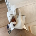 Détail d'un sac seau blanc crème avec fermoir rotatif en métal et pendentifs cœurs - Avec Pendentif / Blanc