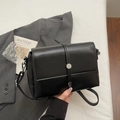 Borsa a tracolla nera minimalista con fibbia argento su sfondo blazer grigio elegante - Nero