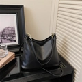 Detalle del bolso tote luna negro con textura de cuero pulido y herrajes dorados finos - Negro