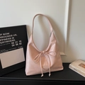 Dettaglio della borsa tote rosa in ecopelle martellata con fiocco e logo del brand - Rosa