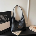 Dettaglio borsa hobo in pelle PU nera opaca con fiocco e logo minimalista - Nero