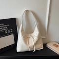 Dettaglio della borsa tote crema con fiocco realizzata in pregiata ecopelle martellata - Bianco Sporco