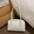 Macro shot of minimalist white leather shoulder bag with sleek dual zipper on wooden floor - White
