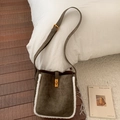 Detailansicht der olivgrünen Wildledertasche mit weißem Plüschrand und goldenem Verschluss - Grün