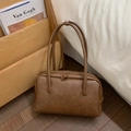 Detailed view of the brown leather texture and stitching on this vintage shoulder bag - Brown