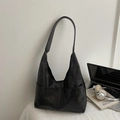 Minimalist black matte suede hobo bag shown with a laptop and book in a lifestyle setting - Black without Pendant