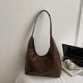 Detail view of large dark brown hobo bag with side pockets in a professional office setting - Brown No Pendant