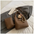 Détail d'un sac seau en cuir litchi marron avec fermoir et breloque ourson doux - Marron avec Pendentif