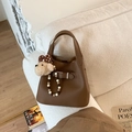 Détail d'un sac seau en cuir marron avec motif litchi et charmant ours en peluche - Marron avec Pendentif