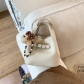 Détail du sac seau en cuir grainé blanc crème avec breloque ours et chaîne en perles - Blanc Avec Pendentif