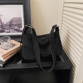 Detail of black suede hobo bag with wide shoulder strap and gold metal buckle - Black
