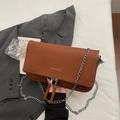 Elegante braune Umhängetasche aus Leder mit Lychee-Muster und Silberkette auf Blazer - Braun