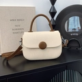 Vista detallada del bolso de lona con detalles en cuero marrón y hebilla decorativa - Blanco Roto