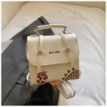 Cream white PU backpack with HELAHE lettering and ladybug pattern on a grey blazer - White