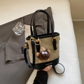 Retro-Eimerbeutel aus Canvas in Beige und Schwarz mit süßem braunem Monster-Anhänger - Mit Monster Plüsch Anhänger / Cremeweiß