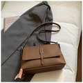 Bolso bandolera vintage de cuero marrón oscuro con hebilla sobre una chaqueta de traje gris - Marrón