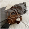 Close-up of brown suede crossbody bag featuring a plush white glove charm and dual handles - Coffee With Pendant