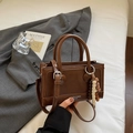 Détail du sac à main en cuir marron avec pendentif en perles et logo de mode élégant - Marron avec pendentif