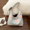 Gros plan du sac hobo bleu clair avec étoiles roses en peluche et bandoulière froncée - Bleu clair