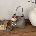 Détail du sac seau gris avec texture grainée et fermoir pivotant en métal argenté - Gris (Avec Pendentif)