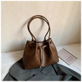 Detalle del bolso tote marrón con textura de cuero y diseño de hebilla de aguja - Marrón