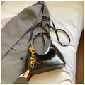 Borsa a mezzaluna nera lucida con ciondolo di perline arancioni su un blazer grigio - Nero con ciondolo
