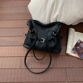 Détail de la boucle argentée et de la texture en cuir noir mat sur le sac à bandoulière souple - Noir