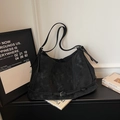 Vista dettagliata della borsa tote nera opaca con eleganti accenti di fibbia in pelle - Nero