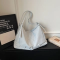 Dettaglio della borsa hobo azzurra con fibbie multiple e texture in pelle morbida - Blu