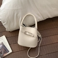 Detailansicht der cremefarbenen Leder-Beuteltasche mit Kieselmaserung und Metallschnalle - Ohne Anhänger / Weiß