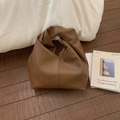 Détail d'un sac en cuir marron foncé avec une poignée nouée au design unique et épuré - Marron
